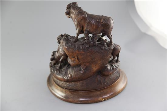A late 19th century Black Forest carved wood group of a bull, two cows and a calf upon a mountain side, height 14in.